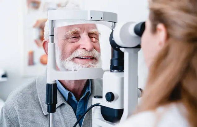 Valokuva, jossa optikko tutkii potilaan silmiä.