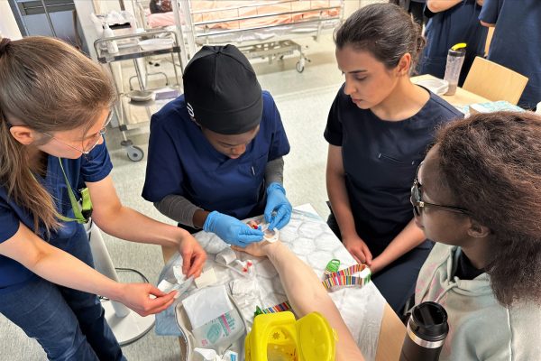 Photo of nursing students performing intravenous cannulation.