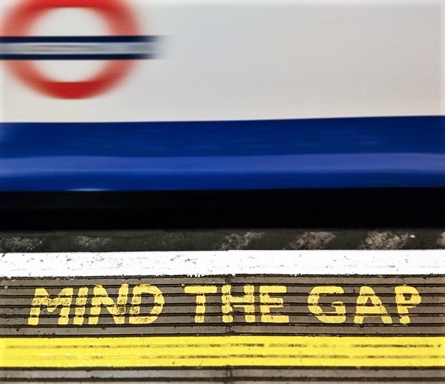 Valokuvassa metrolaituri, jolla teksti Mind the Gap.