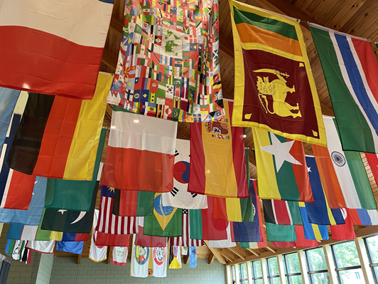 Valokuva, jossa eri maiden lippuja on roikkuun ripustettuna katosta.