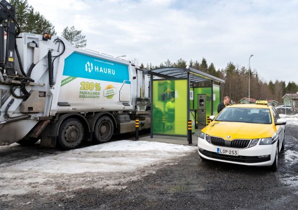Valokuvassa taksi ja jäteauto tankkaamassa biokaasua.
