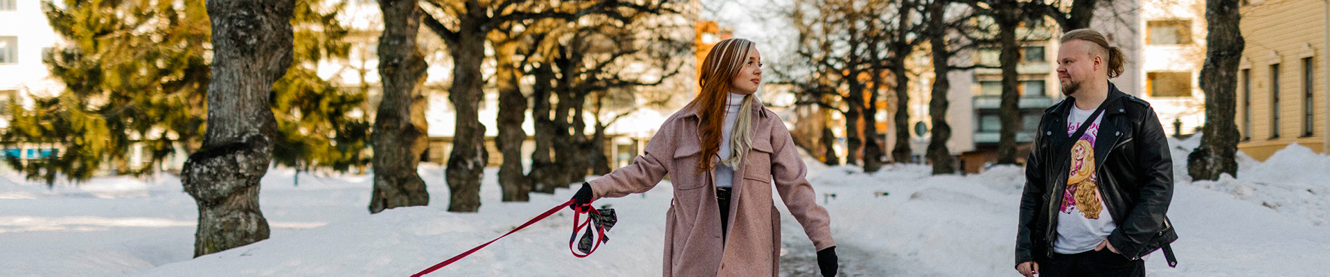 Kaksi henkilöä talviselle puistokujalla katsoo toisiaan.