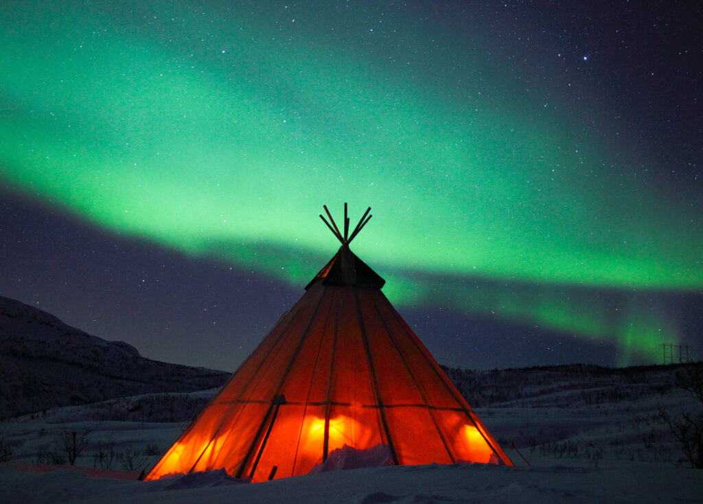 Northern lights over a Sami lavvu.